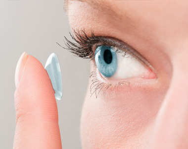 Woman putting lens in eye